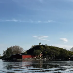 Im Vordergrund Wasser mit einem Gebäude und Hügel. Oslo Sehenswürdigkeiten