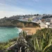 Algarve: Im Vordergrund Pflanzen, im Hintergrund ein Küstenort mit gleichnamigen Strand.